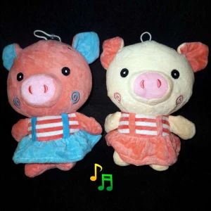 Фото Мягкая игрушка с музыкой Свинья в платье с завитушками 21x15см